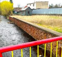 Obrázek z Jarkové ulice, Košice - městská část Šaca, s říčkou a přilehlými pozemky.