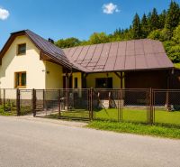 Chata na ulici Černé v Makově s okrasným trávníkem a dřevěným plotem.