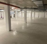 Prostorné obchodní prostory s velkoplošnou podlahou a rovným stropem.