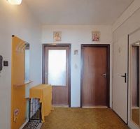 Vstupní předsíň v 2-pokojovém bytě s dřevěnými dveřmi a zrcadlem na stěně.