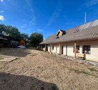 Rodinný dům v Hronské Dúbravě s velkou zahradou a dřevěnými přístavbami.