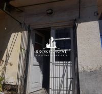 Vstupní dveře s kovovou mřížkou a stěnou rodinného domu v Csobád.