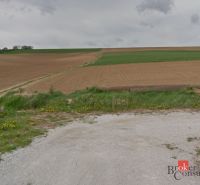 Krajina u Lužánek vhodná pro pozemky - bydlení, s polem a loukou v pozadí.