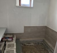 Interiér rodinného domu s oknem a broušenou podlahou, příprava na dlažbu.