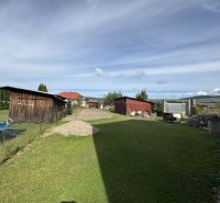 Zahrada za rodinným domem v Plavnici, s přístřeškem, zatravněná plocha a bazén.