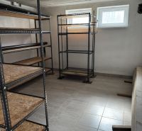 Sklad s kovovými regály a dlažbou v rodinném domě.
