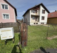 Rodinný dům v Plavnici se zahradou, vedle plynové skříňky na travnaté ploše.