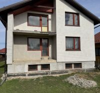 Rodinný dům v Plavnici s jednoduchou fasádou a novými okny, s travnatým pozemkem.