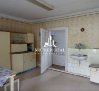 Kuchyně v rodinném domě s vintage nábytkem a umyvadlem, podlaha s dřevěným dekorem.