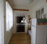 Interiér rodinného domu s bílou lednicí a dekorovanou podlahou s dřevěným dekorem.