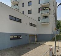 Budova s garáží na Švermově ulici v Banské Bystrici, parkovací sloupky.