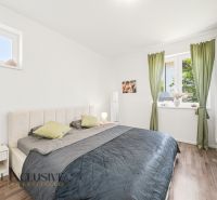 Ložnice s postelí a šatníkovými skříněmi, podlaha s dřevěným dekorem, 3-pokojový byt.
