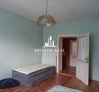 Pokoj v rodinném domě s postelí a podlahou s dřevěným dekorem.