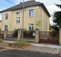 Dvoupatrový bytový dům na Komenského ulici v Nových Zámcích s oplocením z cihel.