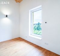 Pokoj v rekreačním apartmánu s podlahou s dřevěným dekorem a velkým oknem.