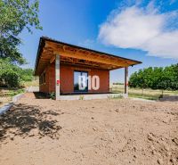Rodinný dům v Čeľadiciach s nedokončenou zahradou, obklopený zelení a modrou oblohou.
