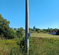 Telefonní sloup na pozemku pro bydlení na Hlavní ulici, Ceroviny, obklopený přírodou.