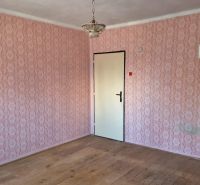 Interiér v rodinném domě s tapetami a podlahou s dřevěným dekorem.
