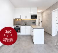 Kuchyně v 2-pokojovém bytě s bílými skříňkami a šedou podlahou.