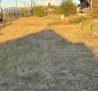 Zahrada u rodinného domu v Blatných Revištích s travnatým porostem a oblohou v pozadí.