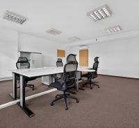 Kanceláře s konferenčním stolem, ergonomickými židlemi a úložnými skříněmi.