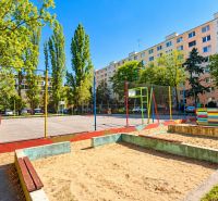Hřiště obklopené zelení a panelovou zástavbou na Rumančekově ulici, Bratislava - Ružinov.
