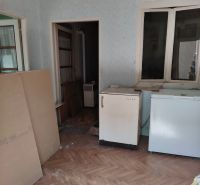 Pokoj v rodinném domě s podlahou s dřevěným dekorem a starším nábytkem.