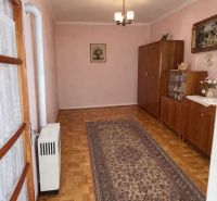 Interiér rodinného domu s podlahou s dřevěným dekorem, kobercem a skříňkami.