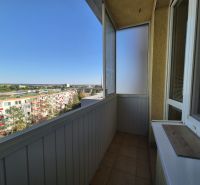 Balkon garsonky s výhledem na Bystrickou ulici v Pezinku, slunečný den.