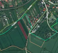 Letecký pohled na zemědělské a lesní pozemky v Podhájske s viditelnou silniční sítí.