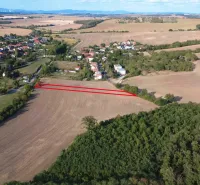 Letecký pohled na zemědělské a lesní pozemky v Podhájské obklopené vesnicí a přírodou.