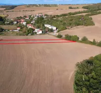 Zemědělské a lesní pozemky v Podhájské, s výhledem na okolní pole a zeleň.