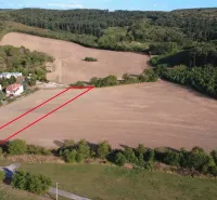 Zemědělské a lesní pozemky v Podhájske s viditelným vymezením, obklopené lesy.