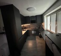 Moderní kuchyně v 2pokojovém bytě s elegantním designem a velkými okny.