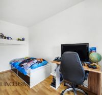 Dětský pokoj v rodinném domě s postelí, stolem a podlahou s dřevěným dekorem.