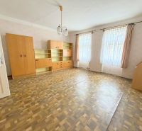 Prostorný obývací pokoj v rodinném domě s vestavěnými skříněmi a podlahou s dřevěným dekorem.