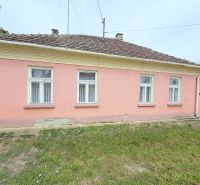 Rodinný dům v Dunakiliti s růžovou fasádou a čtyřmi okny v přízemí.