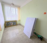 Interiér rodinného domu s obrazem, okny s bílými záclonami a zelenými stěnami.