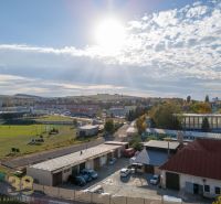 Součástí městské krajiny v Kežmarku jsou garáže a sportovní hřiště pod slunečnou oblohou.