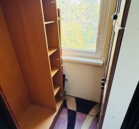 Šatna v 3-pokojovém bytě s výhledem přes velké okno a barevným kobercem.