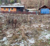 Dřevěné chaty na zasněženém svahu v Oščadnici u rodinného domu.