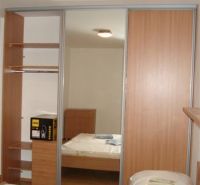 Ložnice s podlahou s dřevěným dekorem a vestavěnou skříní v 3pokojovém bytě.
