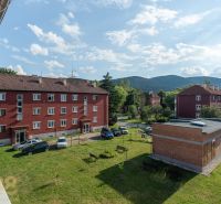 Cihlové budovy s parkovištěm a zelení ve Svitu na ulici 9. května, ideální pro 1-pokojový byt.
