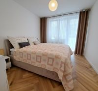 Ložnice s manželskou postelí a podlahou s dřevěným dekorem ve 3pokojovém bytě.