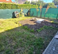 Zahrada rodinného domu na Kupeckého ulici v Piešťanech s trávníkem a záhonem.