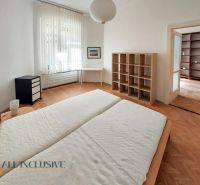 Ložnice s vestavěnou policí, psacím stolem a podlahou s dřevěným dekorem v 2pokojovém bytě.