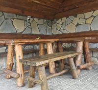 Rustikální koutek s dřevěným nábytkem a kamennou stěnou v Rekreačním apartmánu.