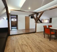 Rekreační apartmán s dřevěnými trámy a podlahou s dřevěným dekorem nabízí jídelní kout.