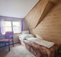 Jednolůžkový pokoj v rekreačním apartmánu s podlahou s dřevěným dekorem a oknem.