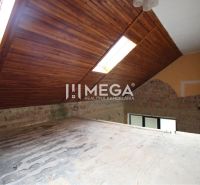 Podkroví rodinného domu s dřevěnými střešními okny, cihlová stěna, světlovody ve střeše.